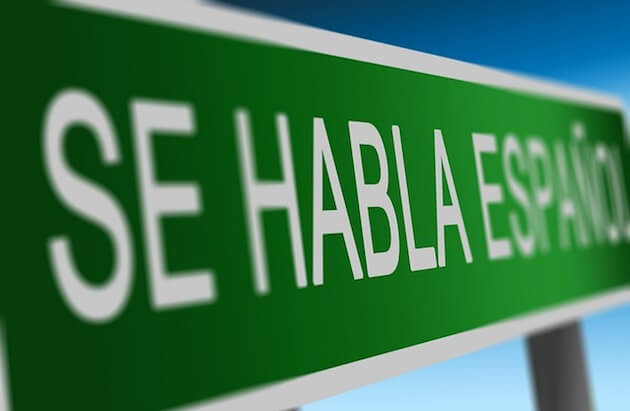 A green sign with the words "se habla español" in white.