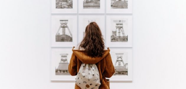A person looking at a selection of artwork in a gallery.