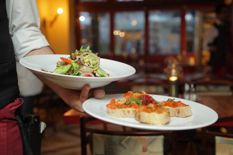 A server carrying two plates.