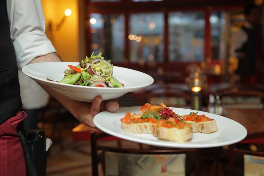 A server carrying two plates.