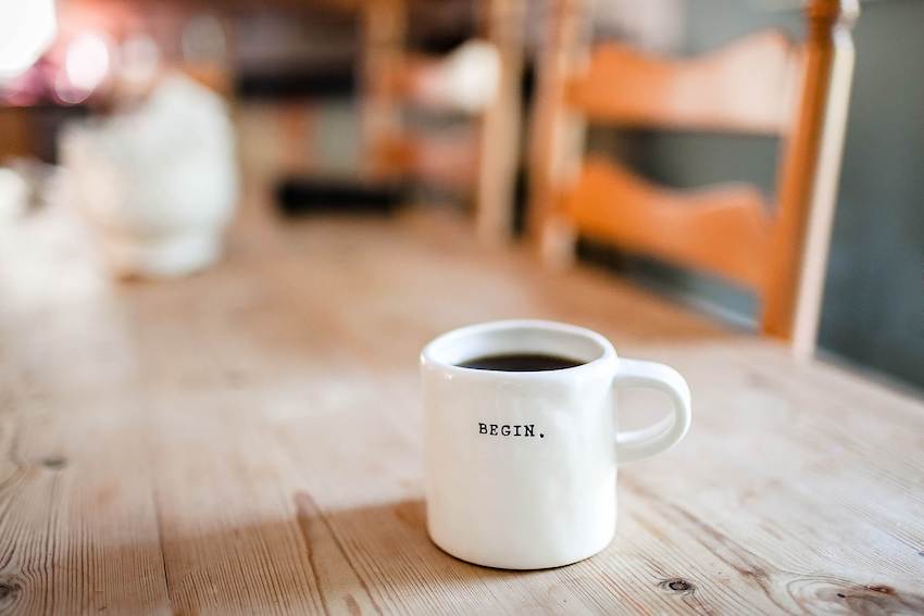 A mug of coffee with the word "begin" printed on it.